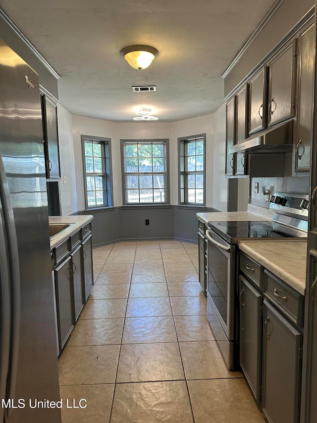 kitchen with sink, light tile patterned flooring, stainless steel appliances, dark brown cabinetry, and exhaust hood