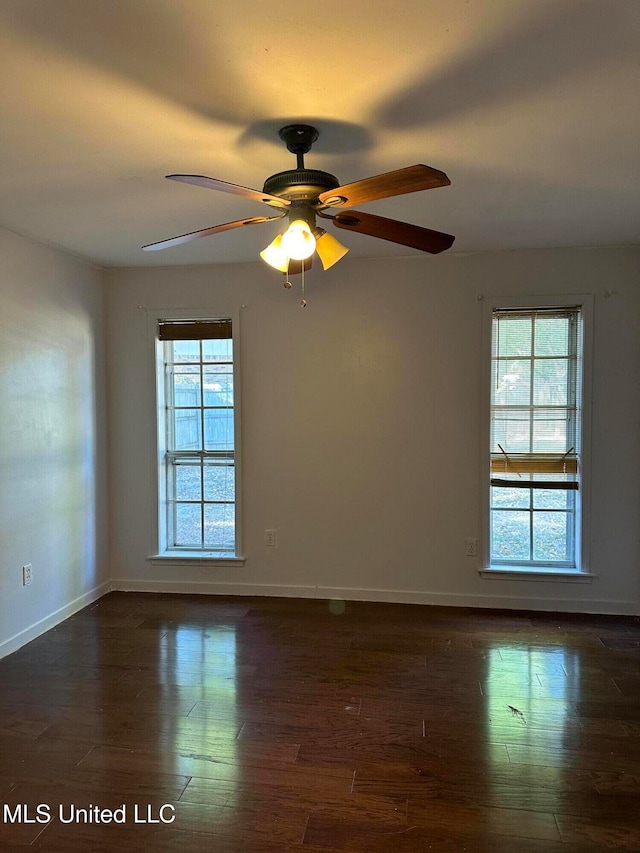 spare room featuring dark wood-type flooring and ceiling fan