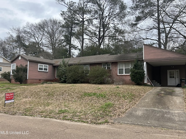 view of front of house featuring driveway, an attached carport, a front yard, and brick siding