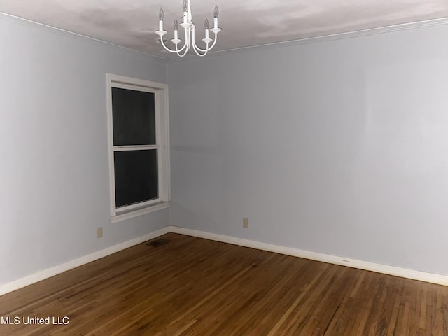 unfurnished room with an inviting chandelier, baseboards, and dark wood-style floors