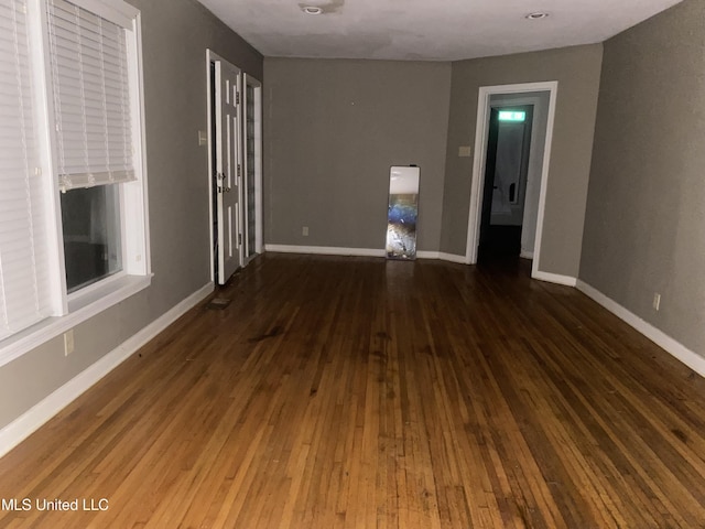 unfurnished room with hardwood / wood-style floors and baseboards