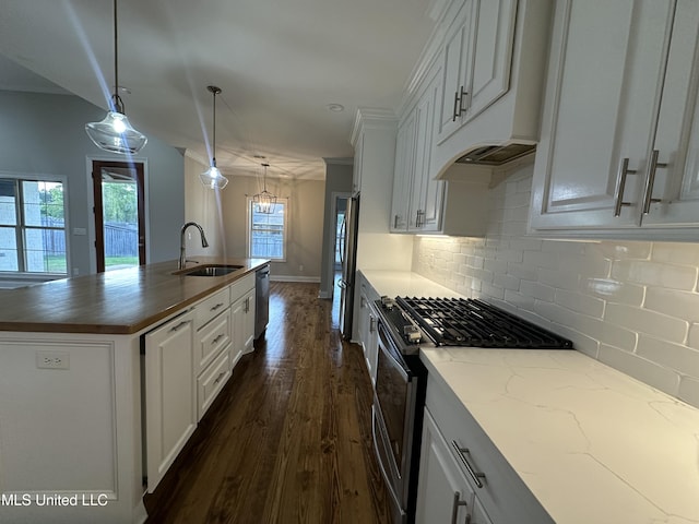 kitchen featuring decorative backsplash, a kitchen island with sink, a sink, stainless steel appliances, and dark wood-type flooring