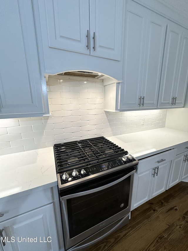 kitchen featuring backsplash, dark wood finished floors, gas stove, and light stone counters