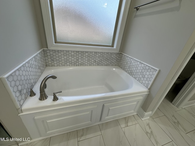 bathroom with a bath and marble finish floor