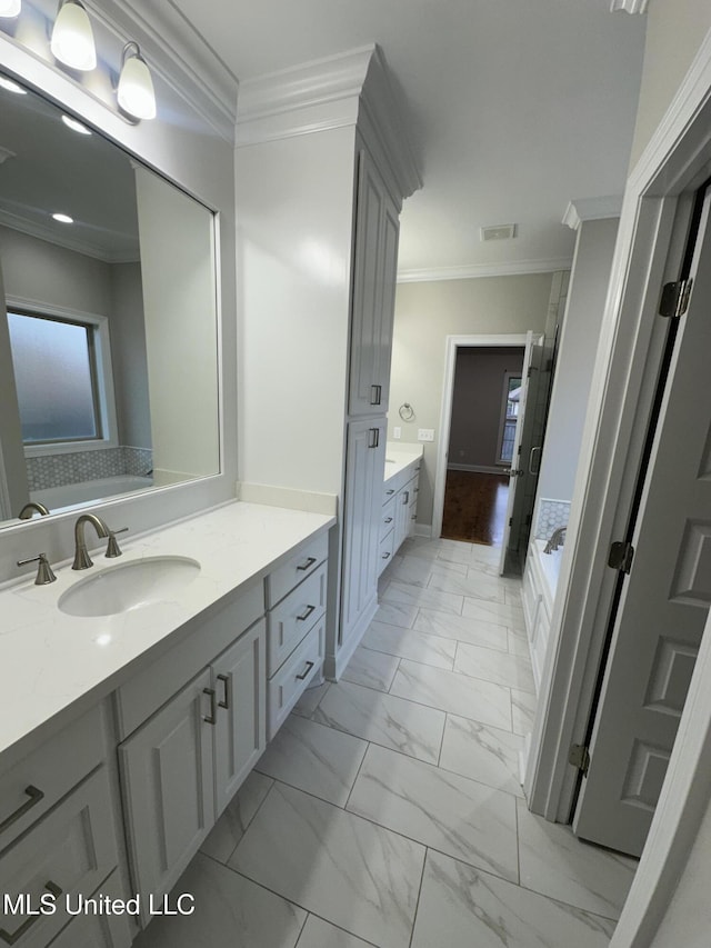 bathroom with vanity, marble finish floor, visible vents, ornamental molding, and a garden tub