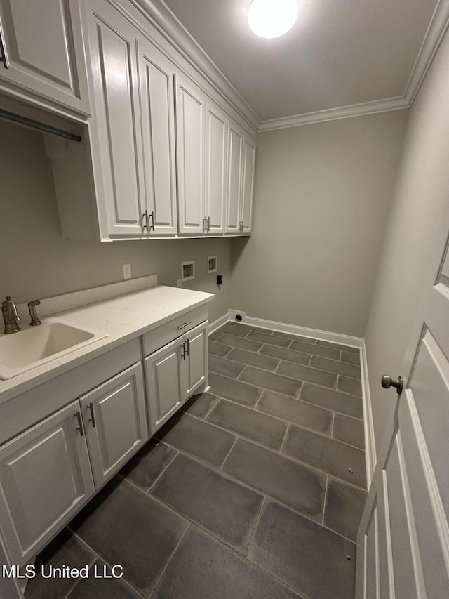 laundry room with cabinet space, a sink, hookup for a washing machine, dark tile patterned floors, and ornamental molding