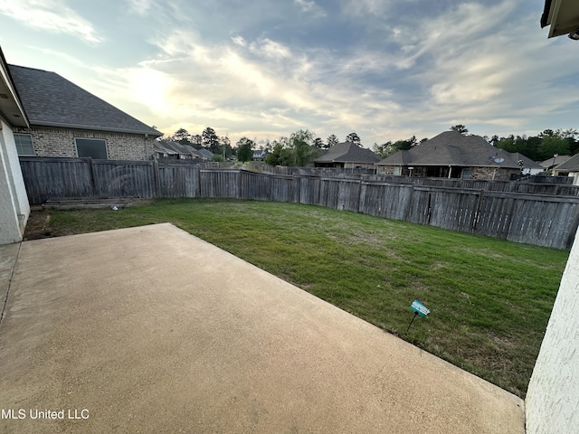 view of yard featuring a residential view, a fenced backyard, and a patio area