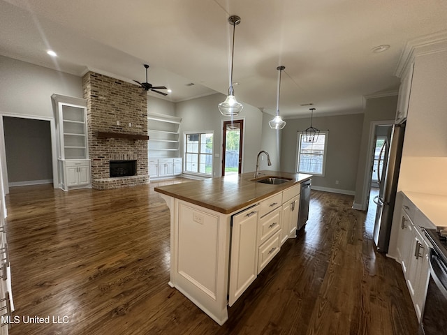kitchen with ornamental molding, a fireplace, ceiling fan, a sink, and stainless steel appliances