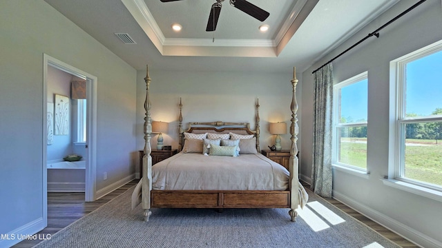 bedroom featuring a tray ceiling, ceiling fan, dark wood-type flooring, and ornamental molding