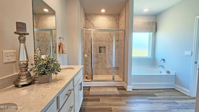 bathroom with separate shower and tub, hardwood / wood-style floors, and vanity