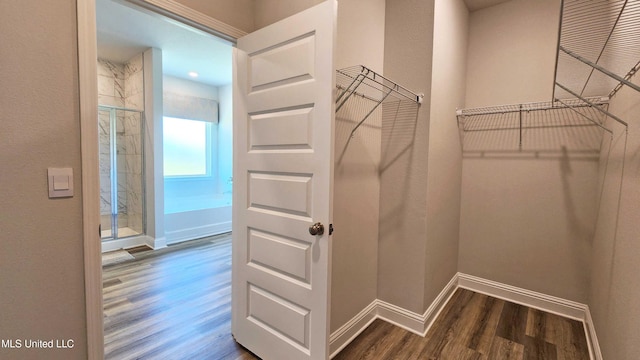 walk in closet with dark wood-type flooring