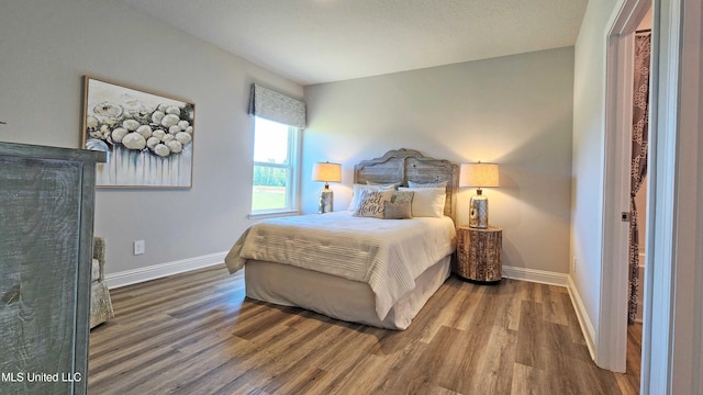 bedroom featuring a textured ceiling and hardwood / wood-style flooring