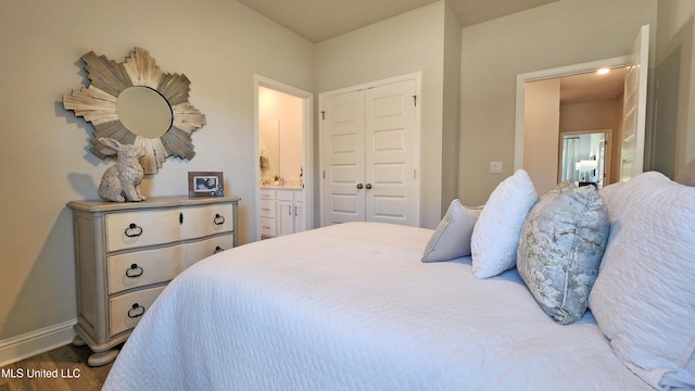 bedroom with connected bathroom, a closet, and hardwood / wood-style flooring