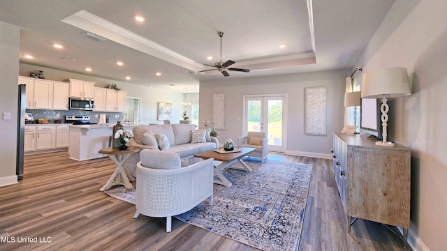 living room featuring a raised ceiling, ceiling fan, french doors, and hardwood / wood-style flooring