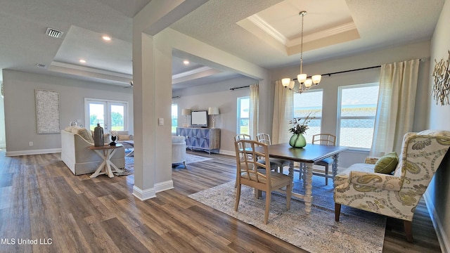 dining area featuring a raised ceiling, a chandelier, crown molding, and dark wood-type flooring