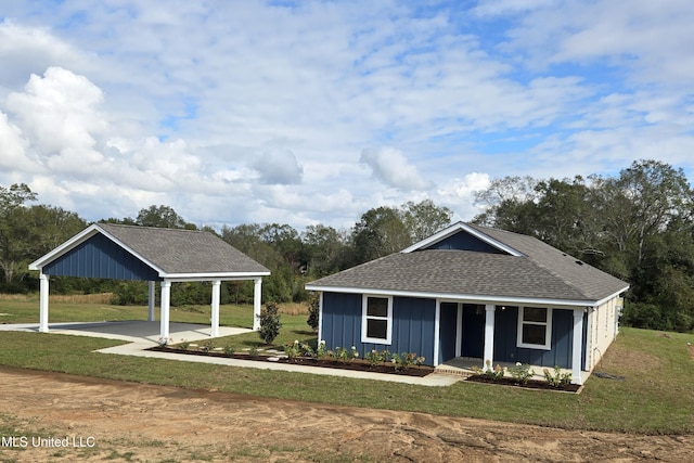 view of front of house with board and batten siding, a shingled roof, and a front lawn