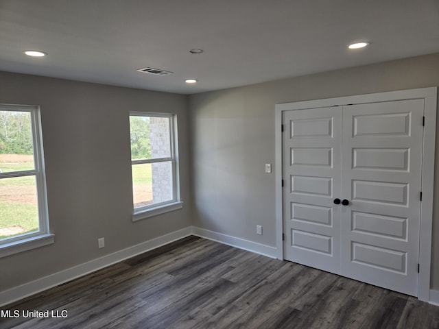spare room with recessed lighting, dark wood-type flooring, and baseboards