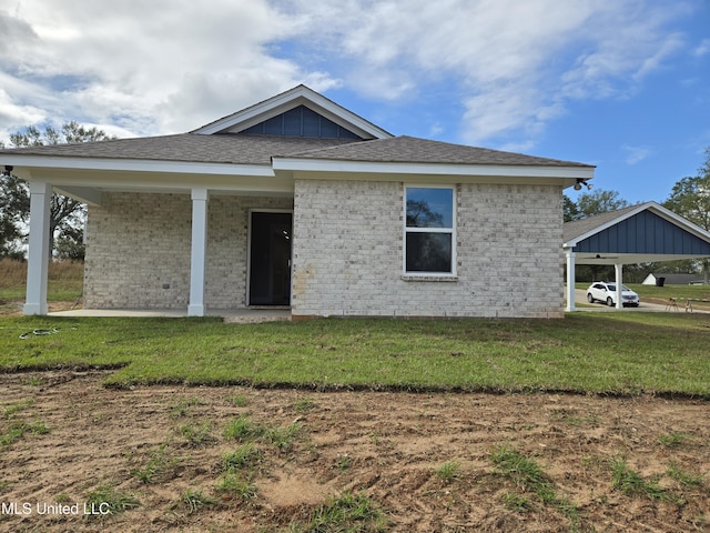single story home with a front lawn, brick siding, and a carport