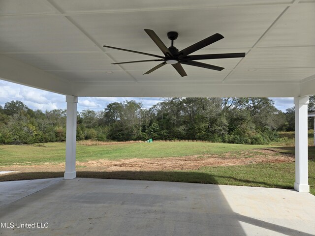 view of patio / terrace featuring a ceiling fan and view of wooded area