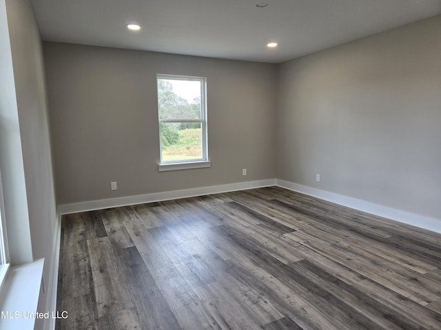 spare room featuring dark wood-style floors, recessed lighting, and baseboards
