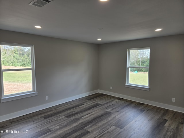 spare room featuring recessed lighting, dark wood-style floors, and baseboards