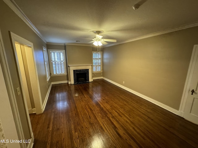 unfurnished living room with ceiling fan, a textured ceiling, ornamental molding, dark wood-type flooring, and a tile fireplace