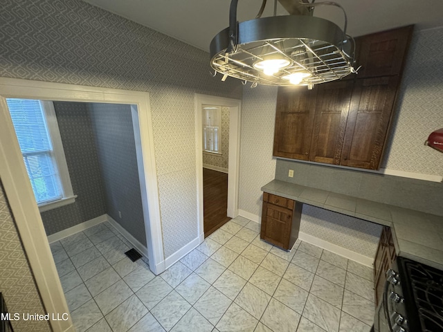 kitchen with stainless steel range oven and light tile patterned flooring