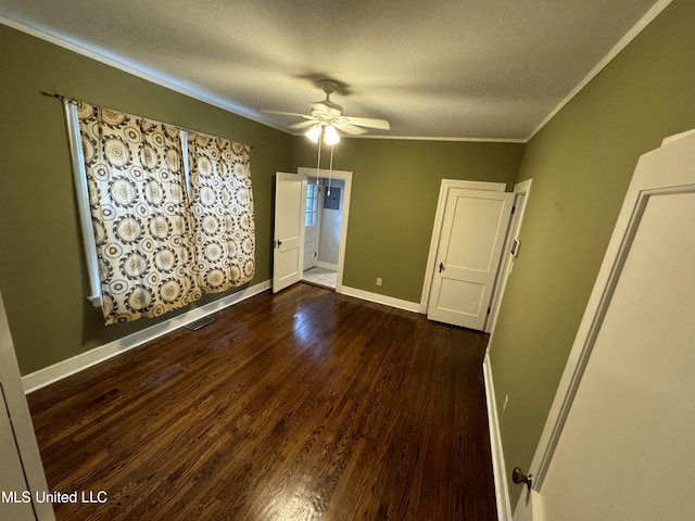 unfurnished room with dark wood-type flooring, crown molding, a textured ceiling, and ceiling fan