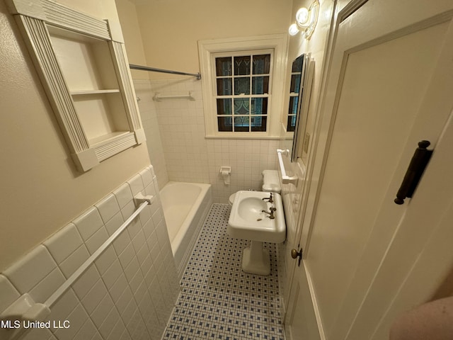 bathroom featuring tile walls, washtub / shower combination, and tile patterned flooring