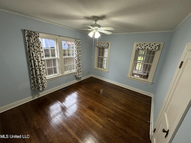 empty room featuring ornamental molding, dark hardwood / wood-style floors, plenty of natural light, and ceiling fan