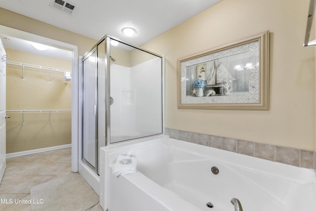 2228 Beach Dr Unit 907, Gulfport, MS 39507 - full bathroom featuring a stall shower, a garden tub, a spacious closet, and tile patterned flooring