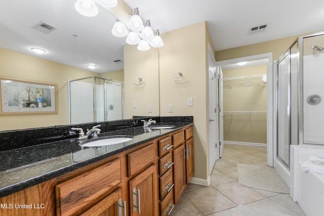 bathroom featuring tile patterned flooring, vanity, and a shower with door