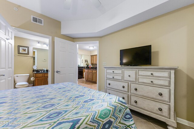 tiled bedroom featuring ensuite bathroom and ceiling fan