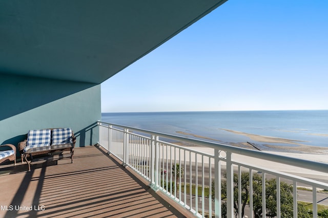 balcony with a water view and a view of the beach