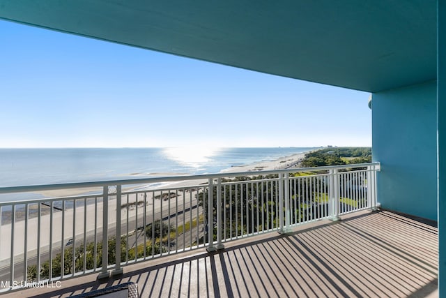 balcony featuring a view of the beach and a water view