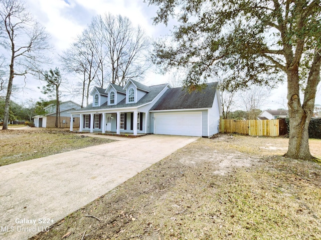 cape cod house with a garage, a front yard, and covered porch