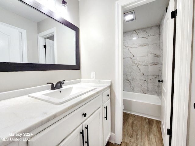 bathroom with vanity, tiled shower / bath combo, and hardwood / wood-style floors