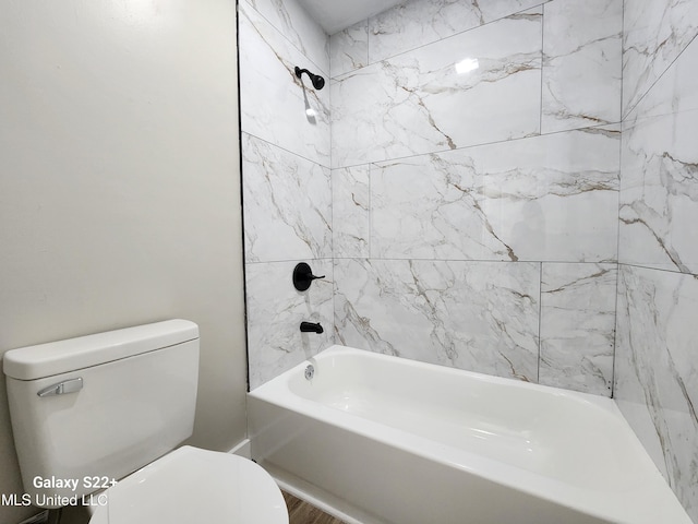 bathroom featuring tiled shower / bath and toilet