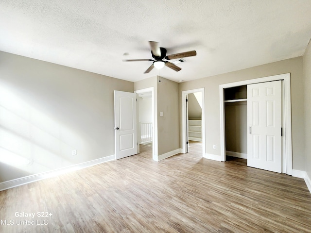 unfurnished bedroom featuring ceiling fan, hardwood / wood-style floors, a textured ceiling, and a closet