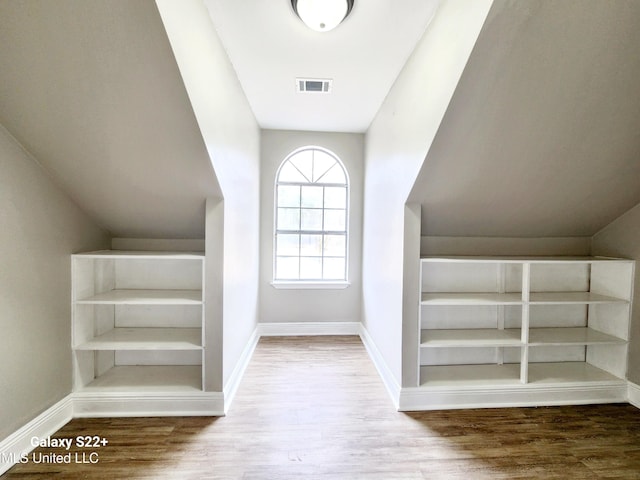 interior space with hardwood / wood-style flooring and lofted ceiling