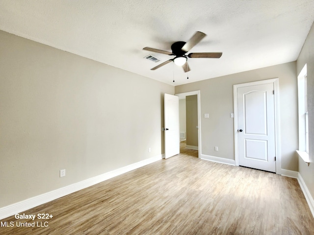 unfurnished bedroom featuring ceiling fan, light hardwood / wood-style flooring, and a textured ceiling