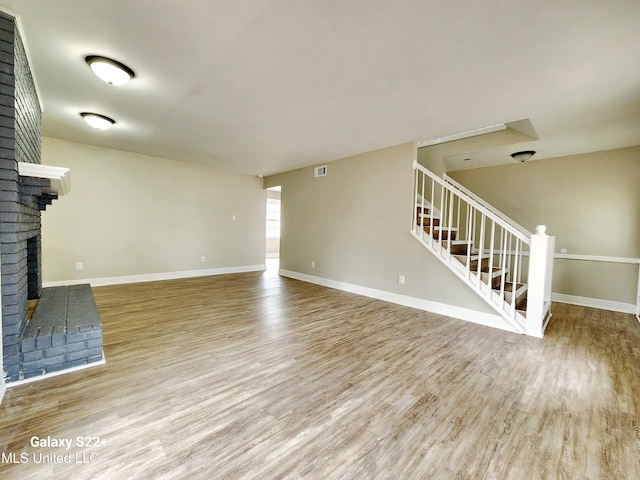 unfurnished living room featuring hardwood / wood-style flooring and a fireplace