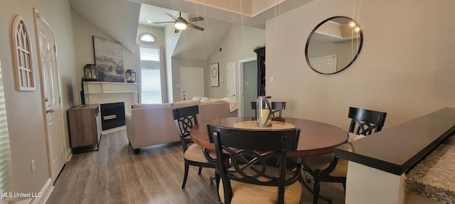 8422 Kaleki Way, Diamondhead, MS 39525 - dining area with wood finished floors, a fireplace, a ceiling fan, high vaulted ceiling, and baseboards