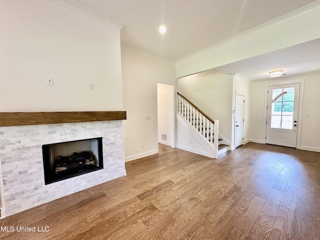 unfurnished living room with ornamental molding and wood-type flooring