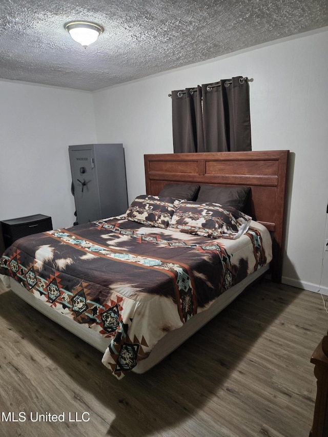 bedroom featuring wood finished floors and a textured ceiling
