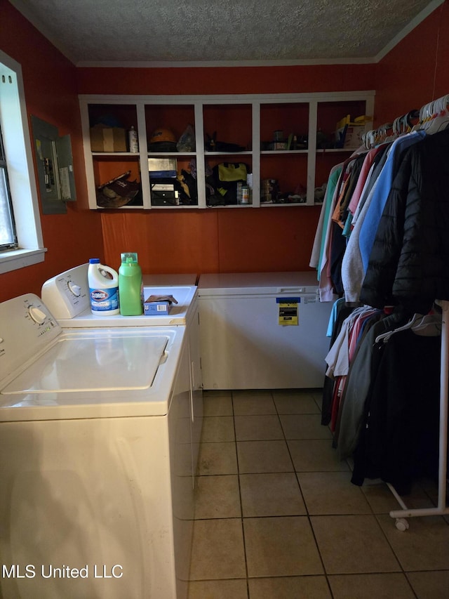 clothes washing area with washer and dryer, electric panel, tile patterned flooring, a textured ceiling, and crown molding