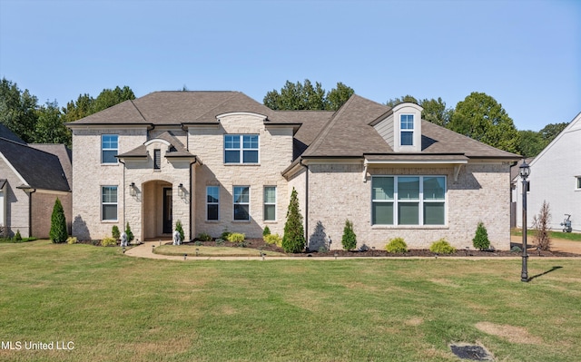 french country inspired facade with a front lawn