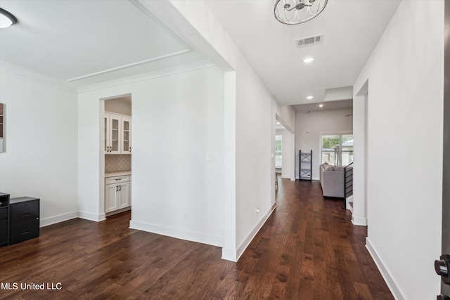 corridor with ornamental molding and dark hardwood / wood-style flooring