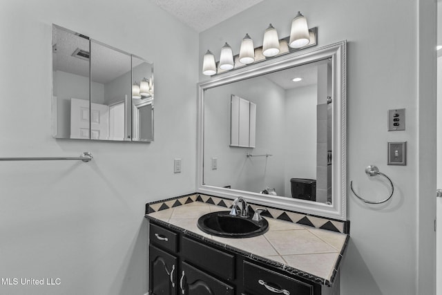 bathroom featuring a textured ceiling and vanity