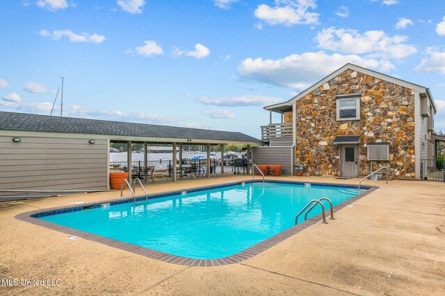 community pool featuring a patio and fence